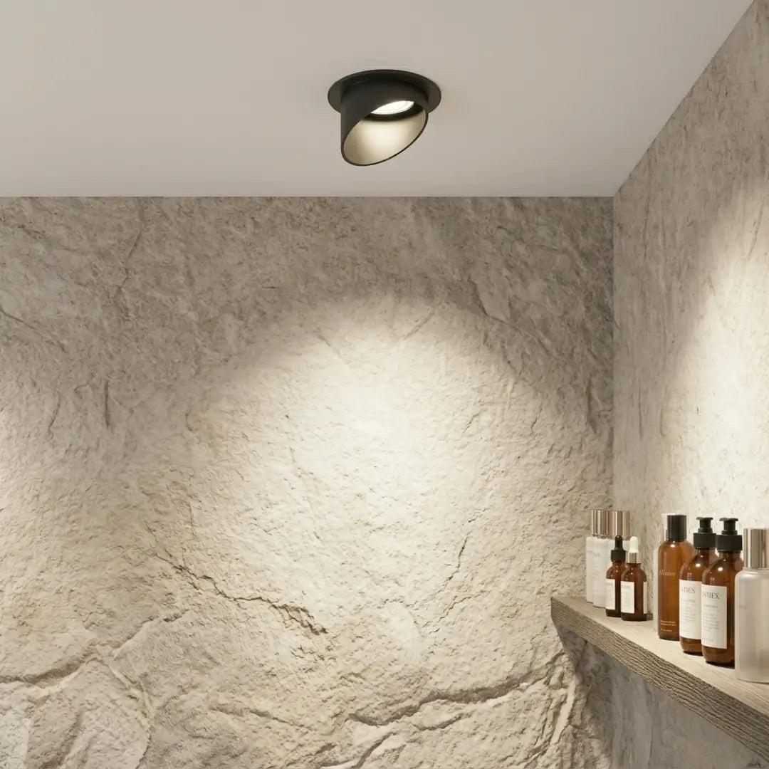Ceiling light fixture in a room with stone walls and shelves holding bottles.