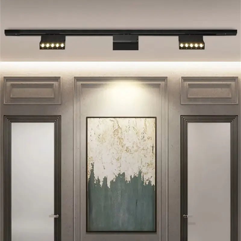 Modern wall-mounted light fixture above a door with a painting.