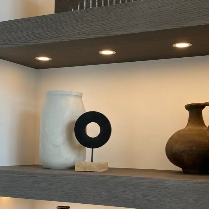 Three decorative vases on a shelf with a neutral background