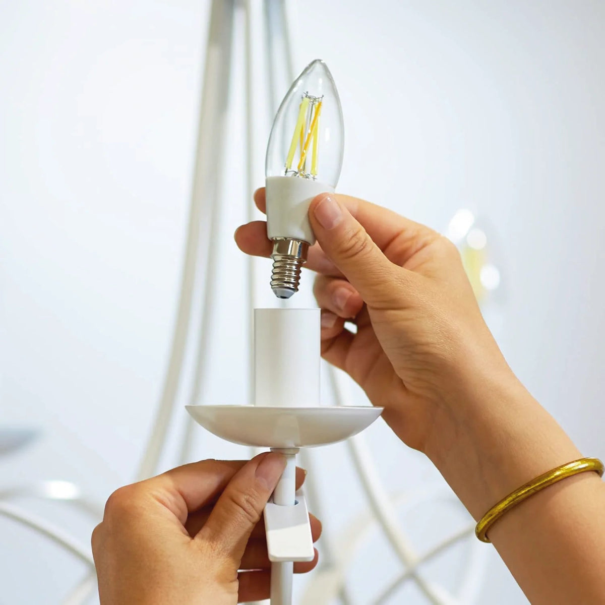 Person holding a white LED light bulb with a blurred background