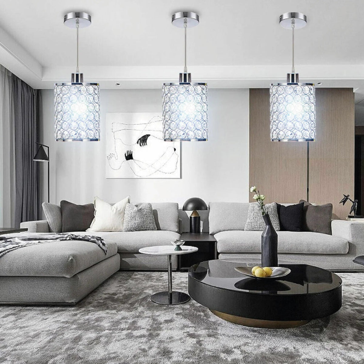Modern living room with gray sectional sofa, black coffee table, and pendant lights.