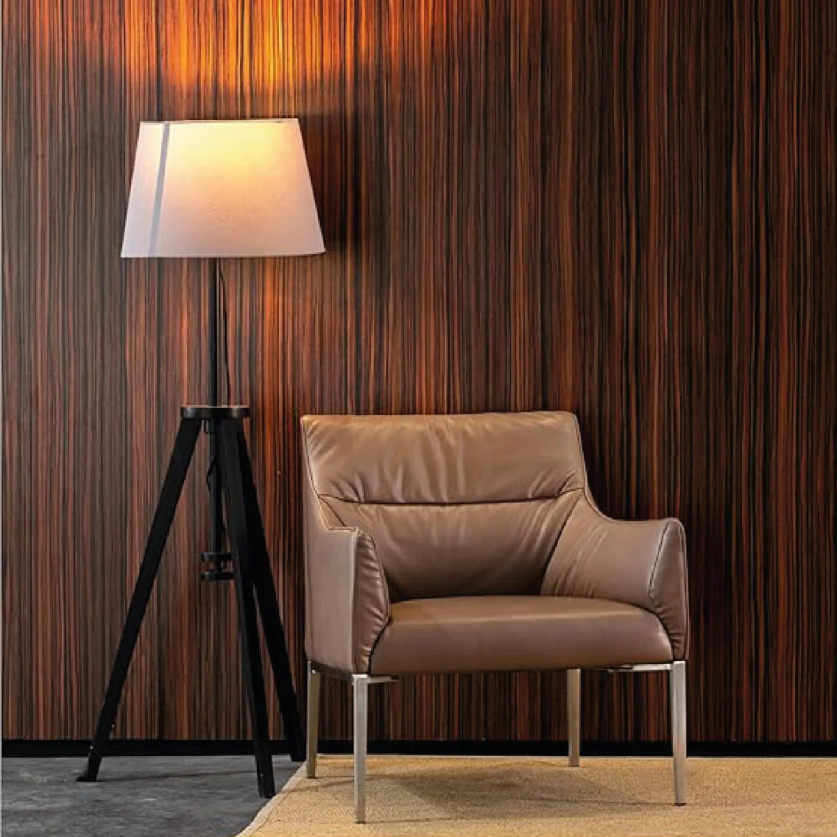 Brown leather armchair in a room with wooden wall and floor lamp.