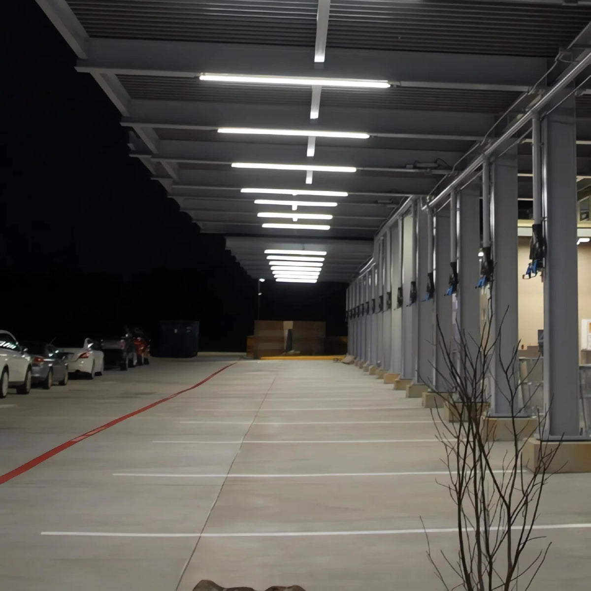 Long, narrow indoor parking garage with cars parked at the end