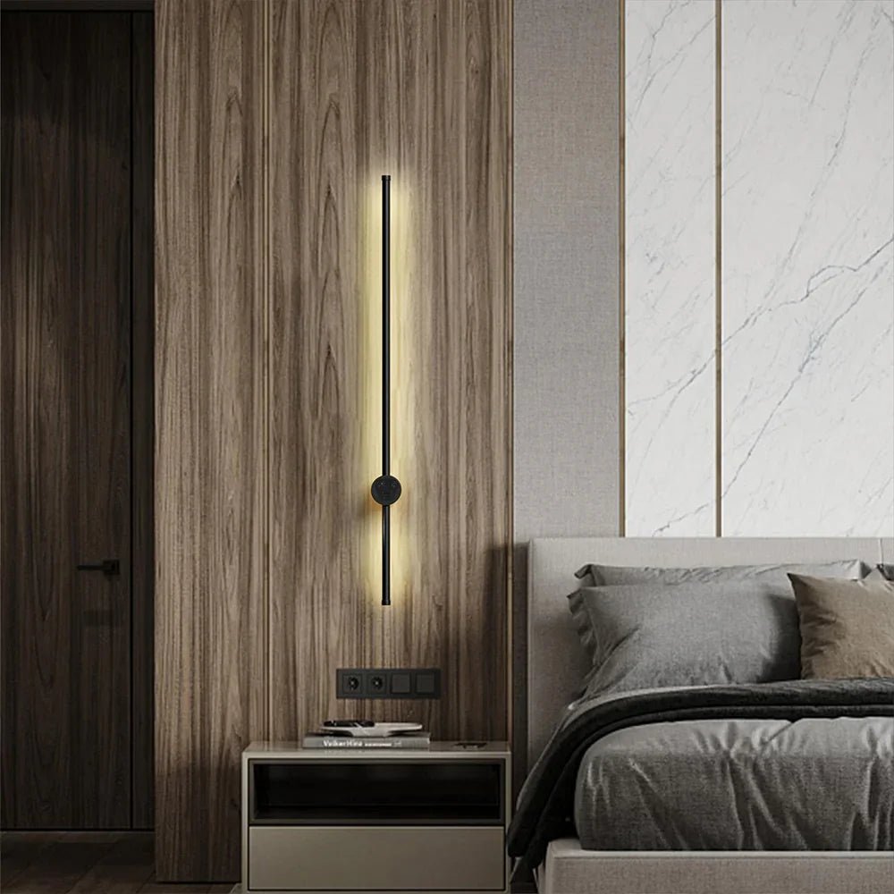 Modern bedroom with a wall-mounted light fixture and a bed.