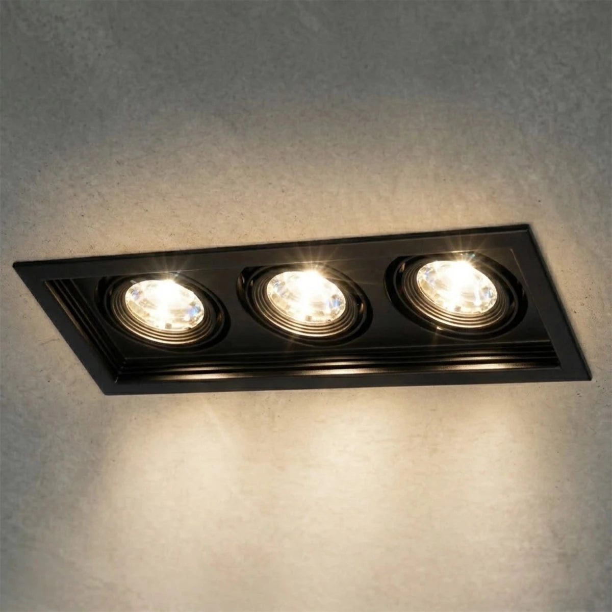 Three-light recessed ceiling fixture on a gray wall