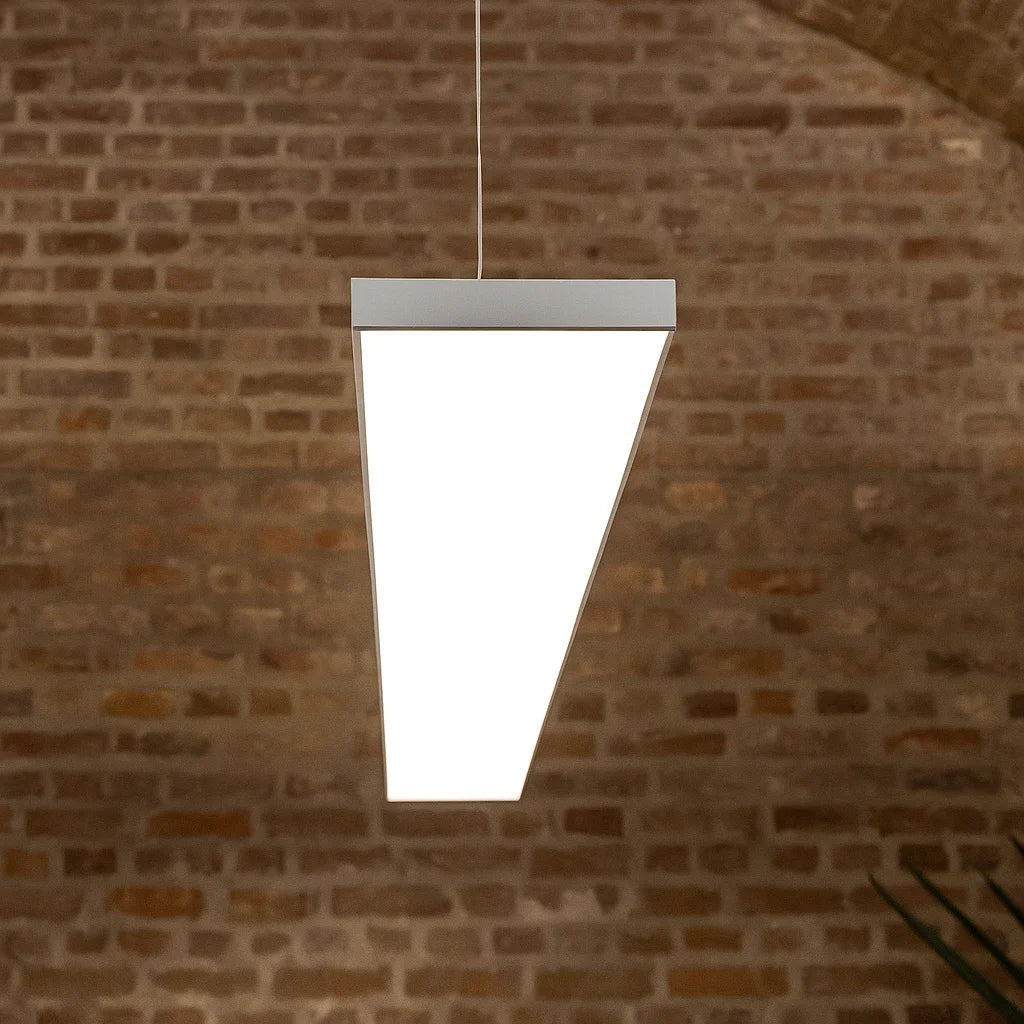White pendant light fixture hanging against a brick wall