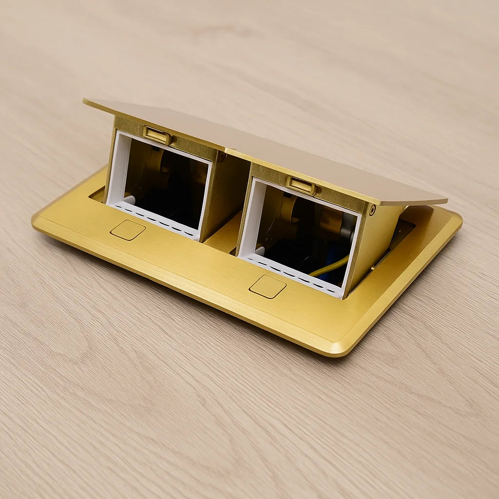 Gold desk panel with two power outlets on a wooden surface