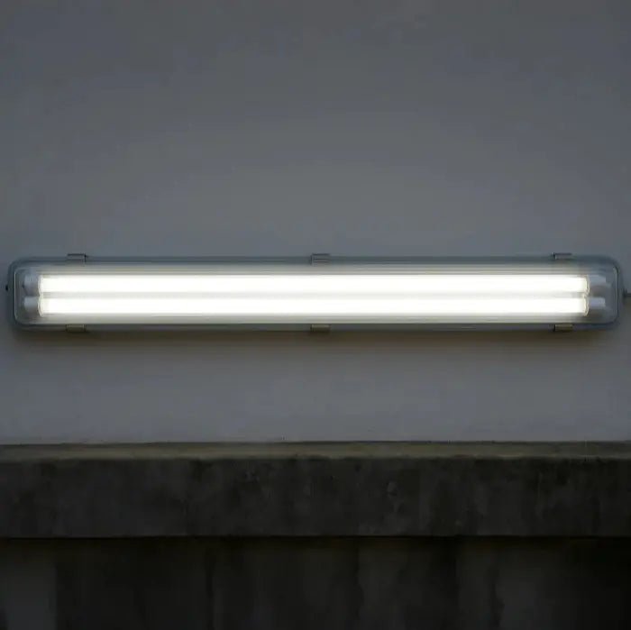 Fluorescent light fixture on a wall with a dark background