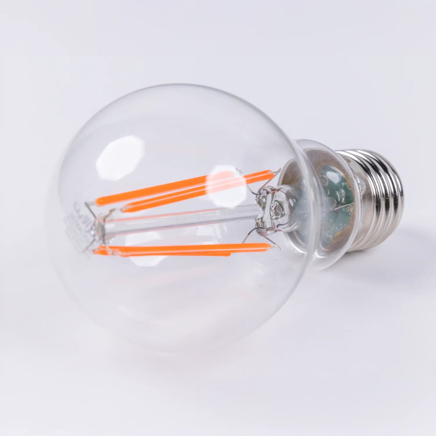 Clear light bulb with visible filaments on a white background