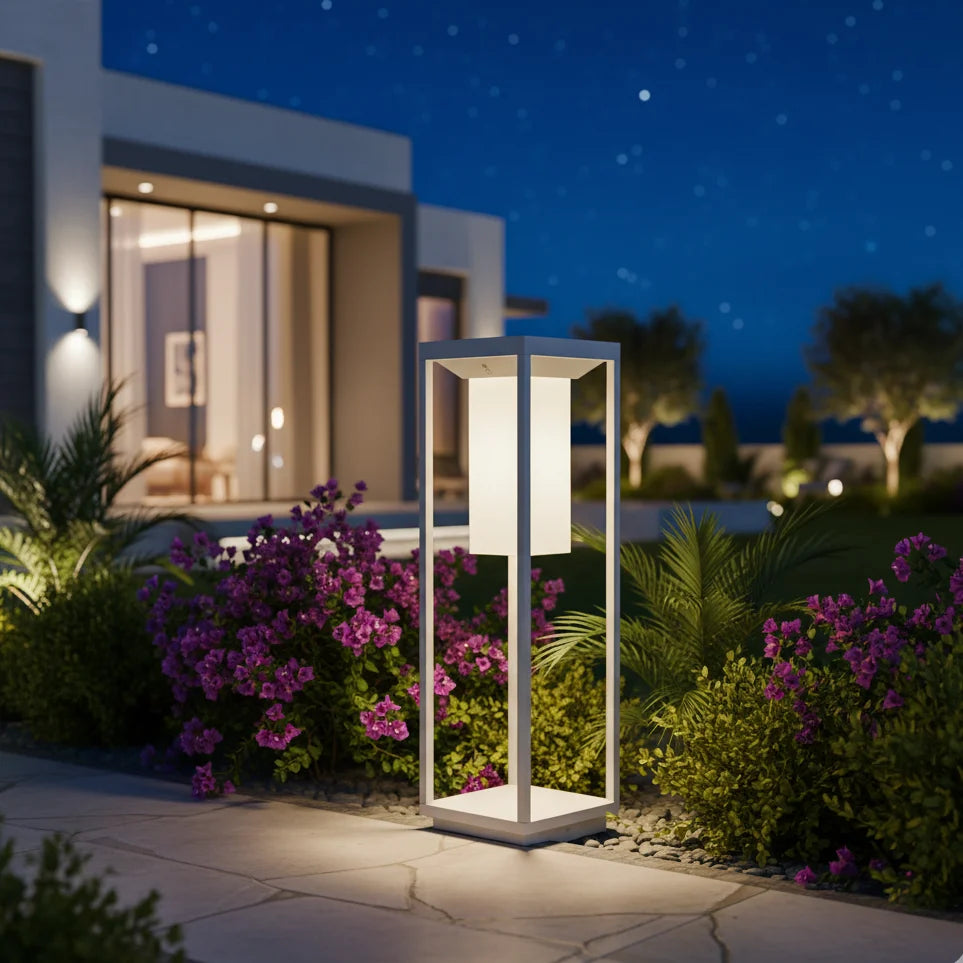 Garden lamp post with flowers and building in the background at night