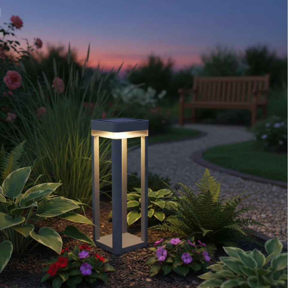 Garden light fixture in a garden setting with plants and a bench at dusk.