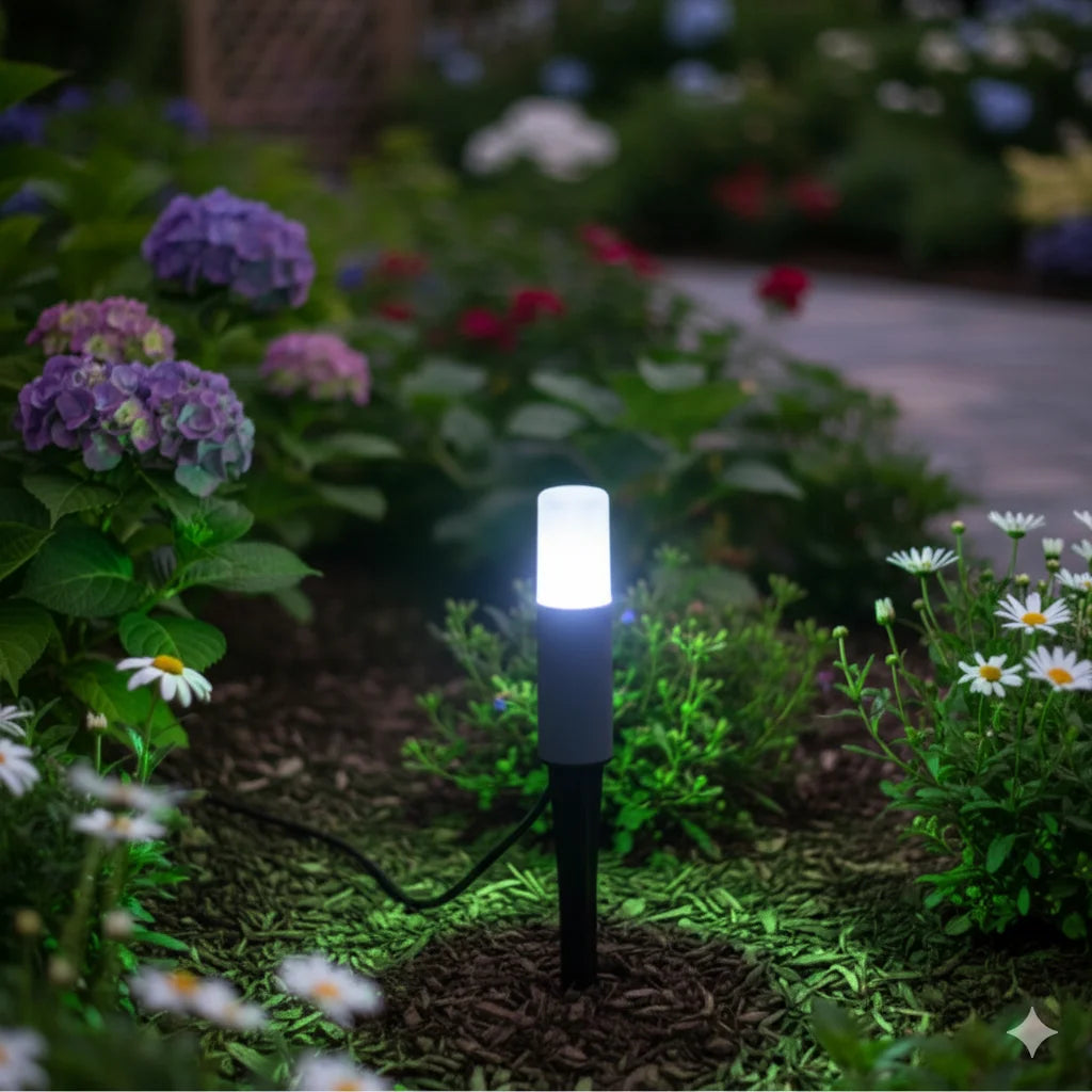 Solar garden light in a garden setting with flowers and plants.