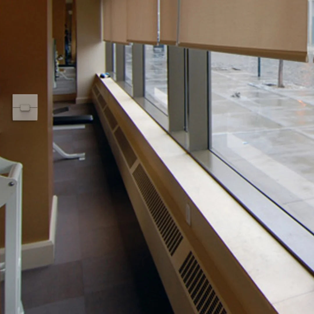 Window with beige blinds in a room with a radiator and a door.