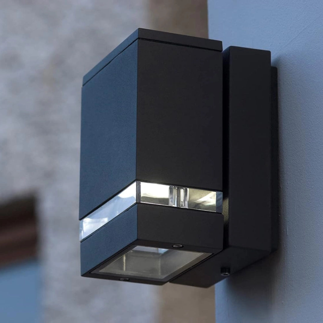 Black outdoor wall light fixture on a gray wall