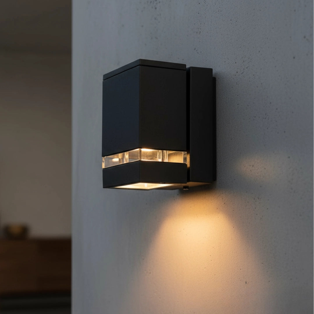 Black outdoor wall light fixture on a concrete wall