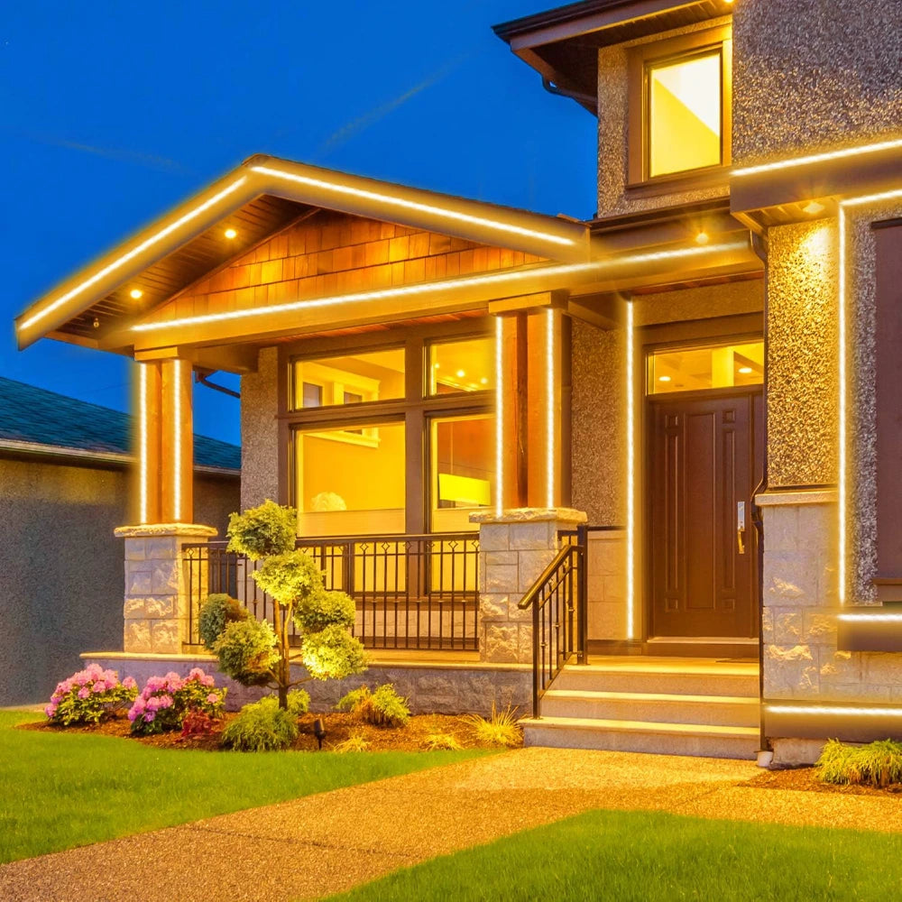 Elegant house exterior with illuminated windows and decorative lights at night.