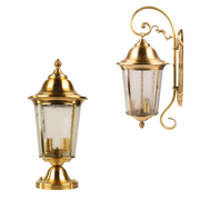 Two gold outdoor wall lights with glass shades on a white background