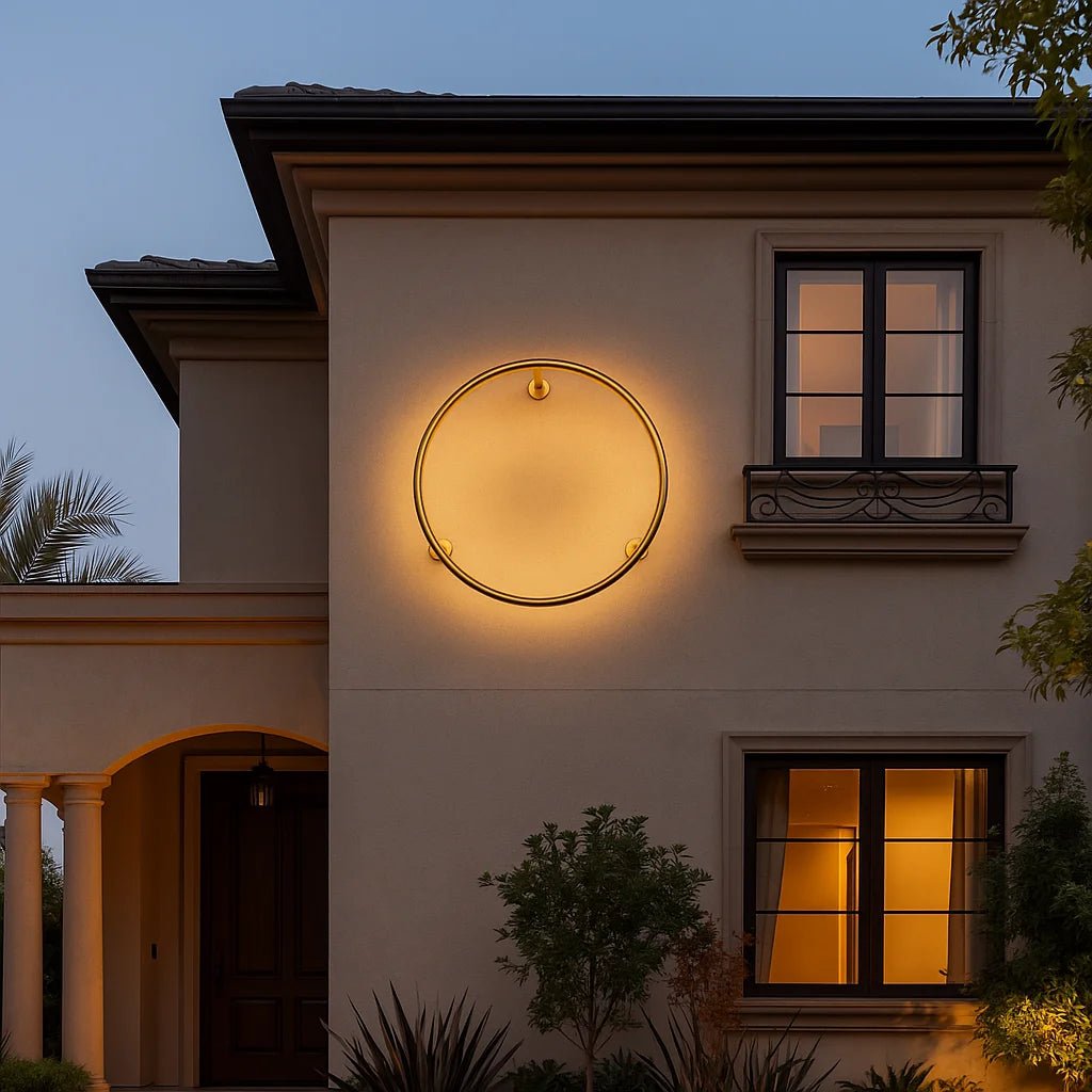 Round wall light fixture on a house exterior with warm glow