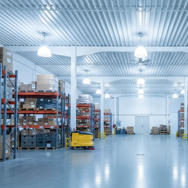 Large warehouse with shelves and boxes, featuring a forklift in the center.