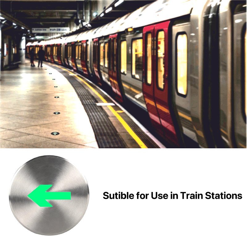 Subway train at a station with a metallic button labeled 'Suitable for Use in Train Stations' featuring a green arrow.