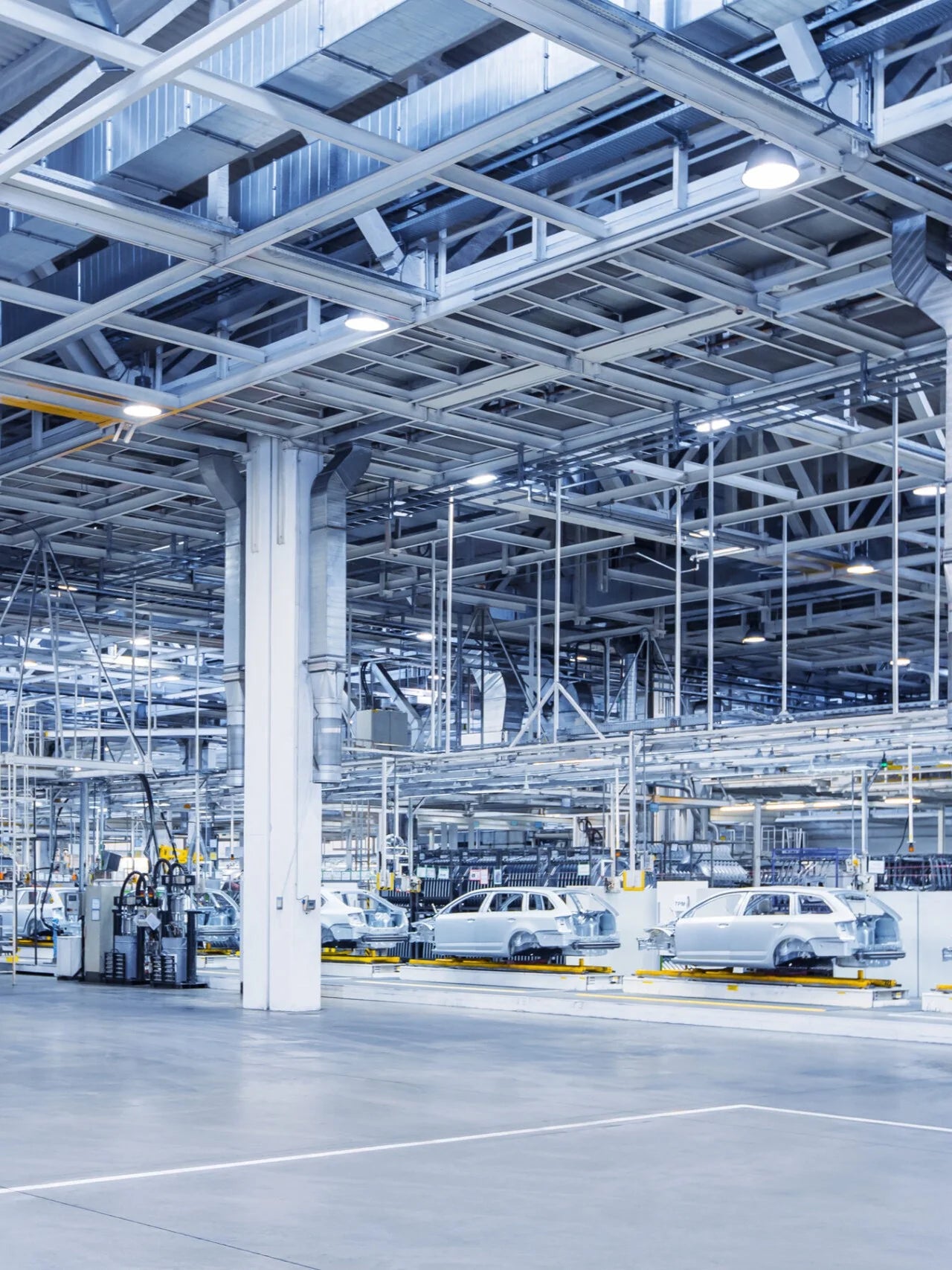 Automotive assembly line in a factory with cars in various stages of production.