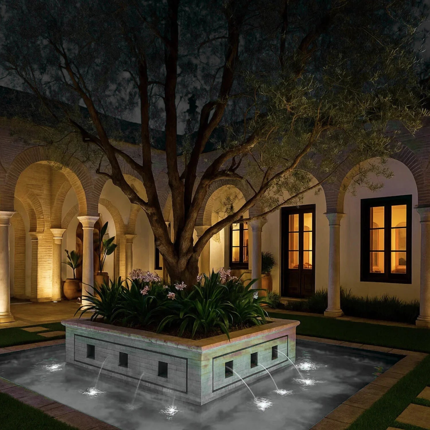Decorative fountain in a courtyard with arches and trees at night.
