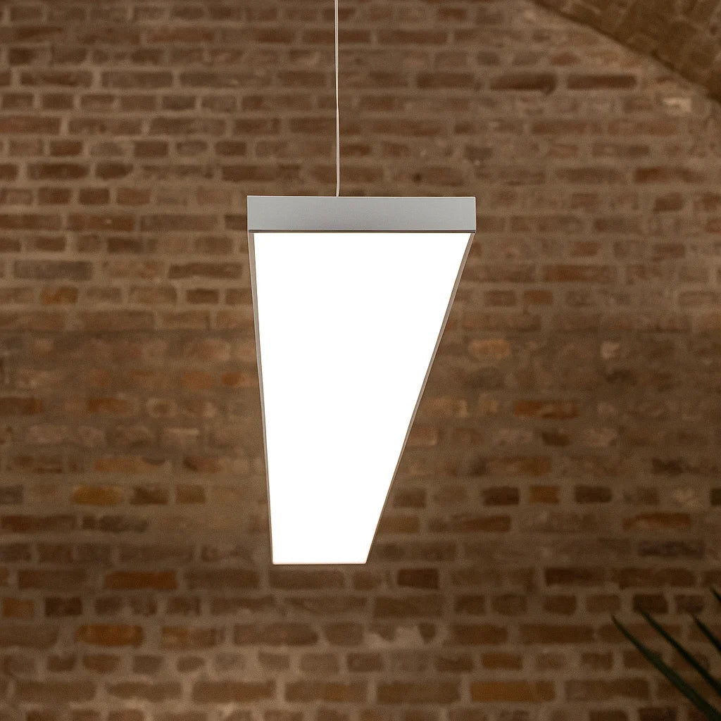 White pendant light fixture hanging against a brick wall