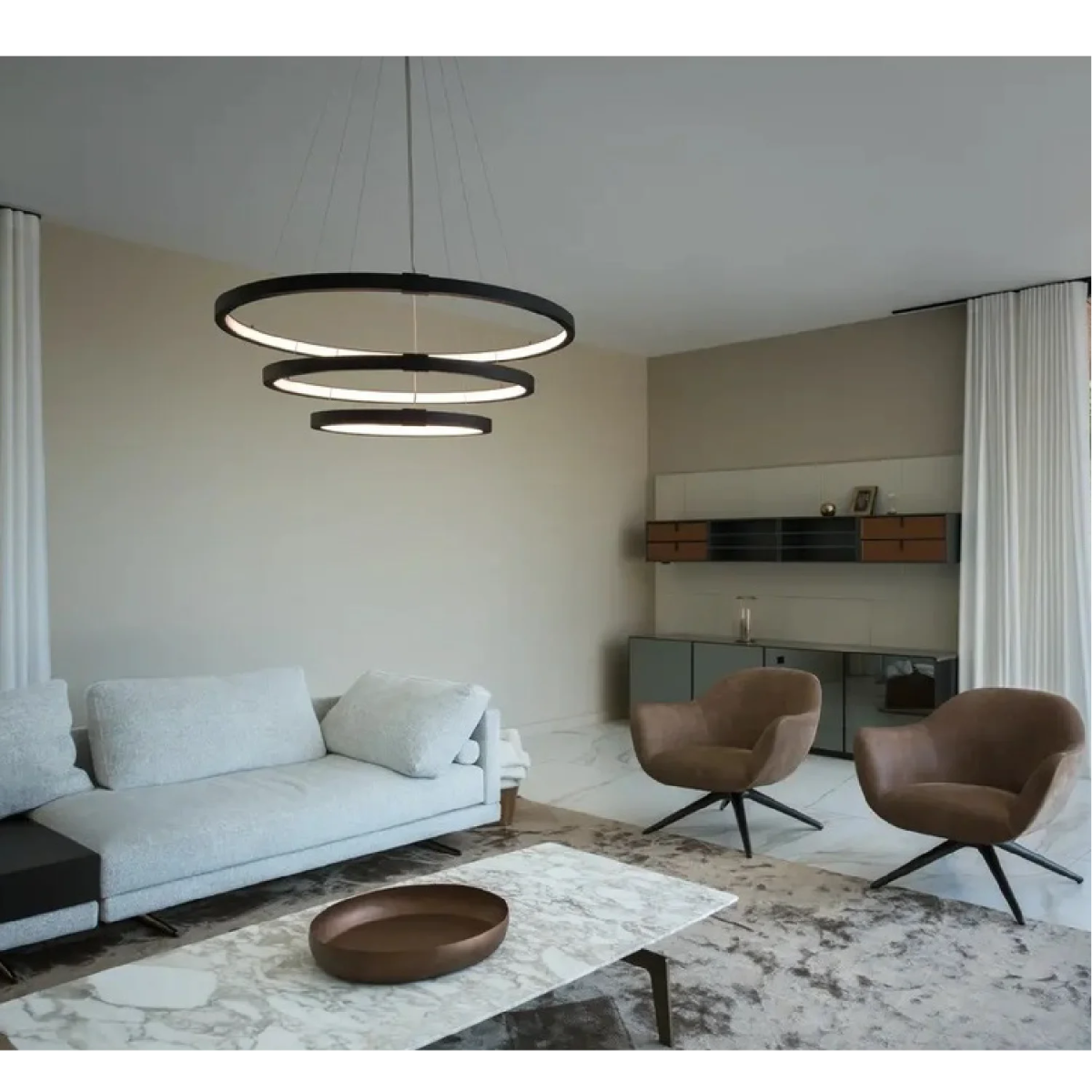 Modern living room with a chandelier, sofa, and chairs.