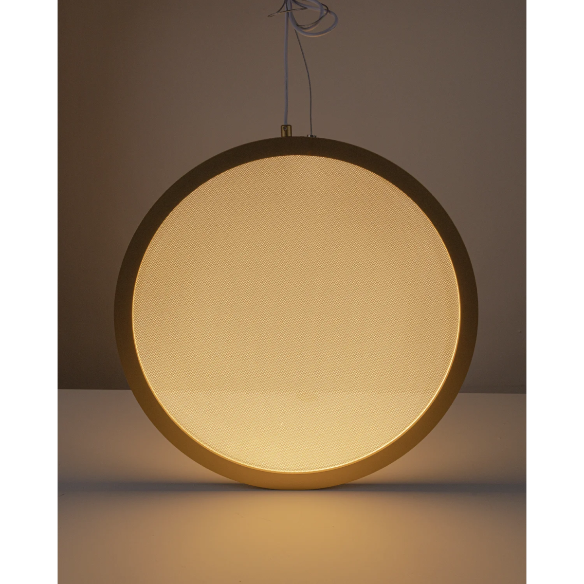 Round pendant light with a warm glow on a dark background