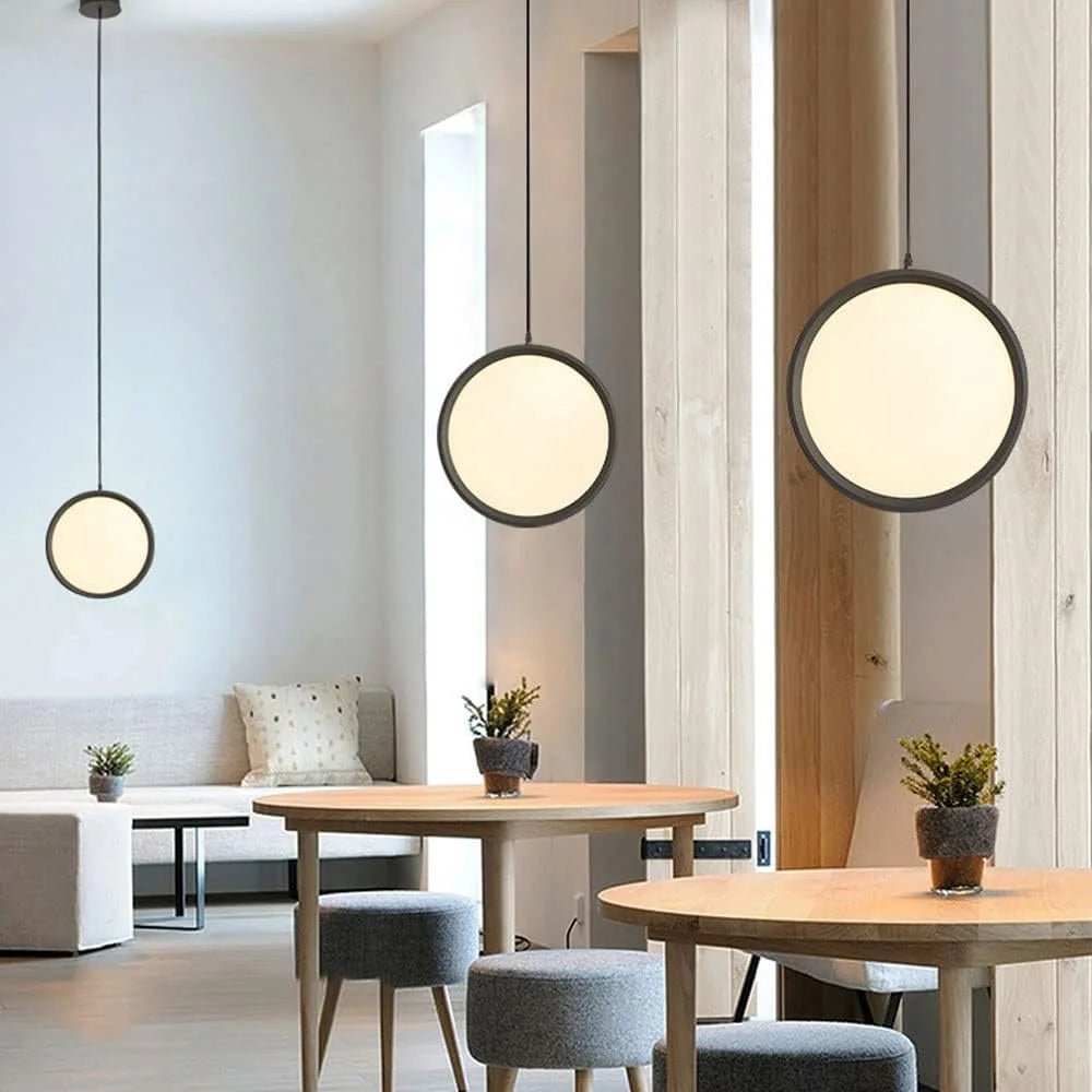 Modern interior with round pendant lights, wooden tables, and gray chairs.