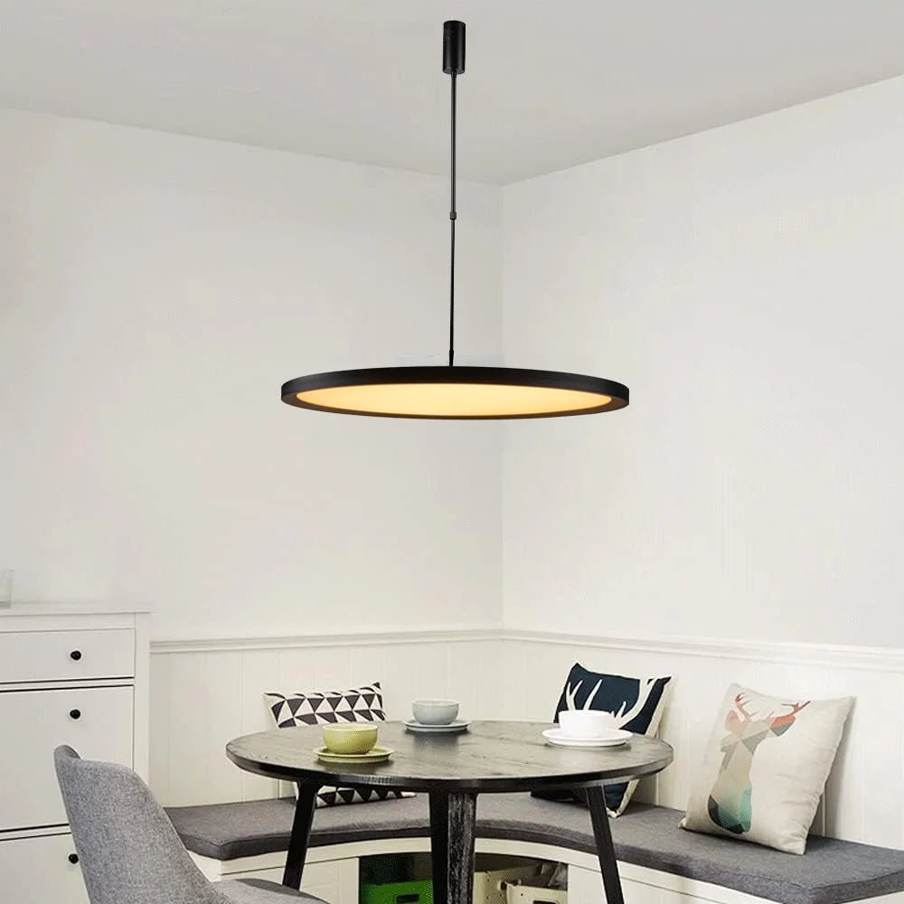 Dining area with a round table, chairs, and a pendant light fixture.