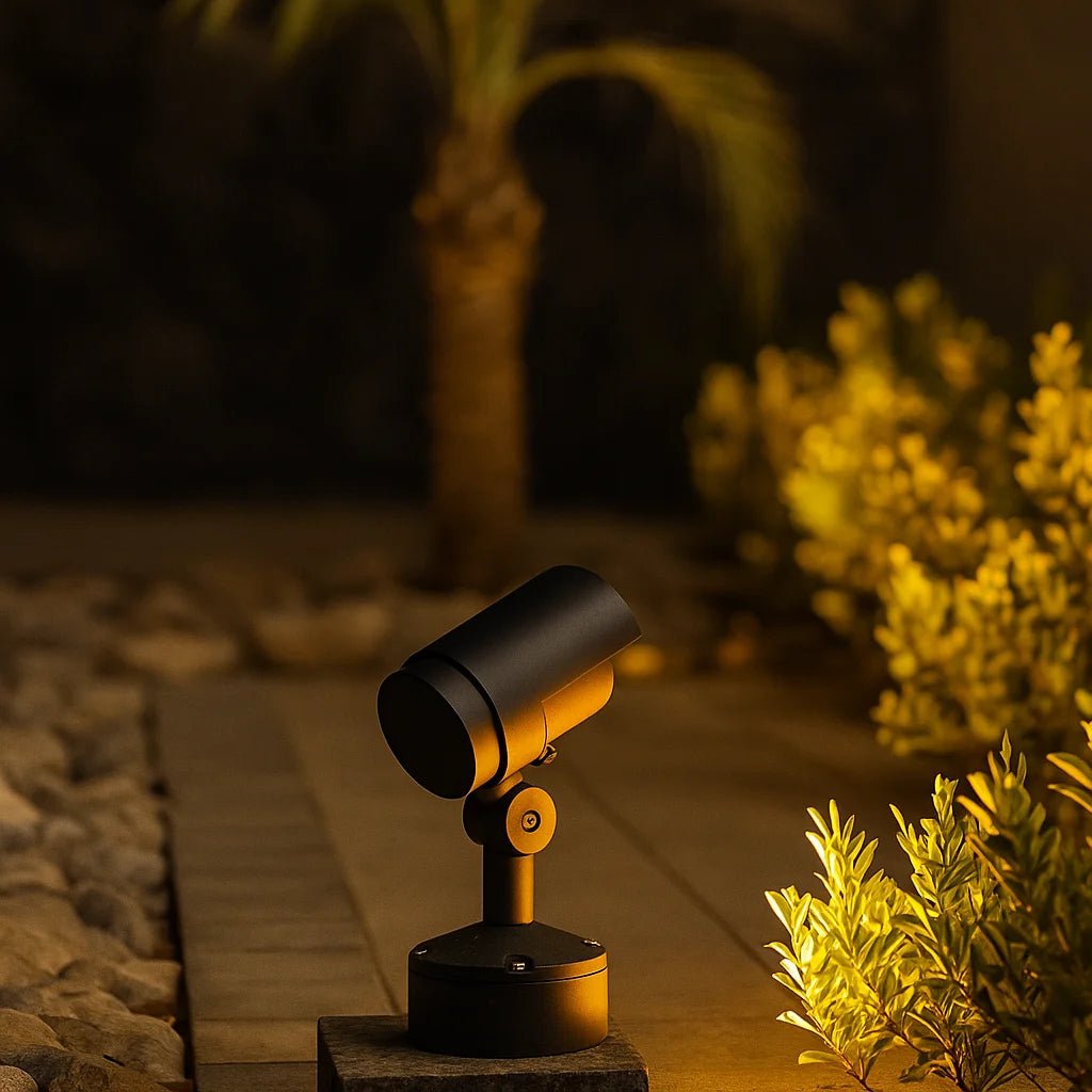 Decorative outdoor light fixture on a stone pathway with plants in the background