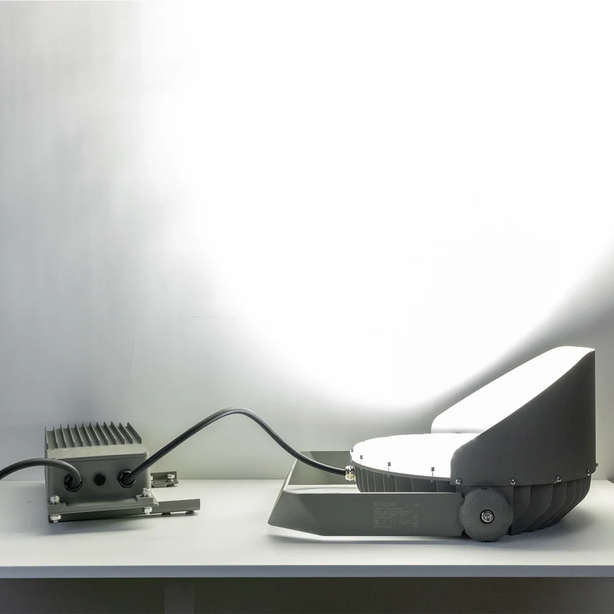 Small robot or device on a white surface with a neutral background