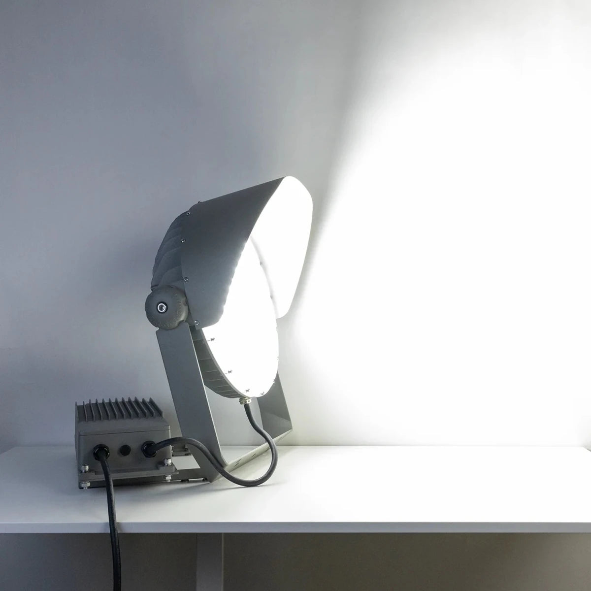 Modern outdoor light fixture on a white surface with a gray background