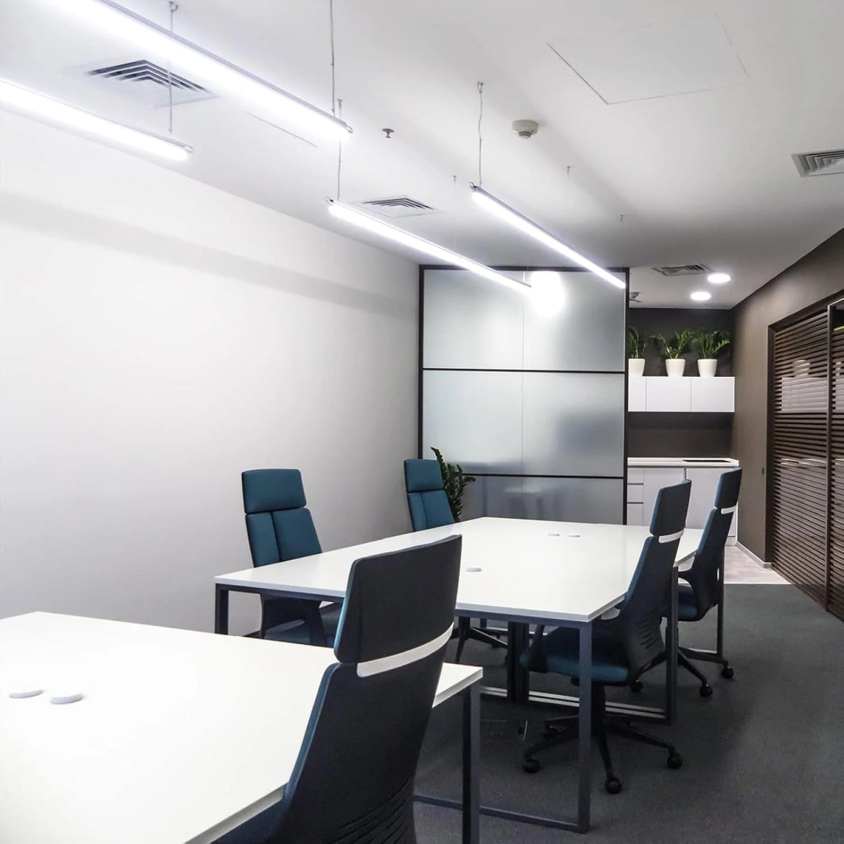 Modern office conference room with white tables and blue chairs.