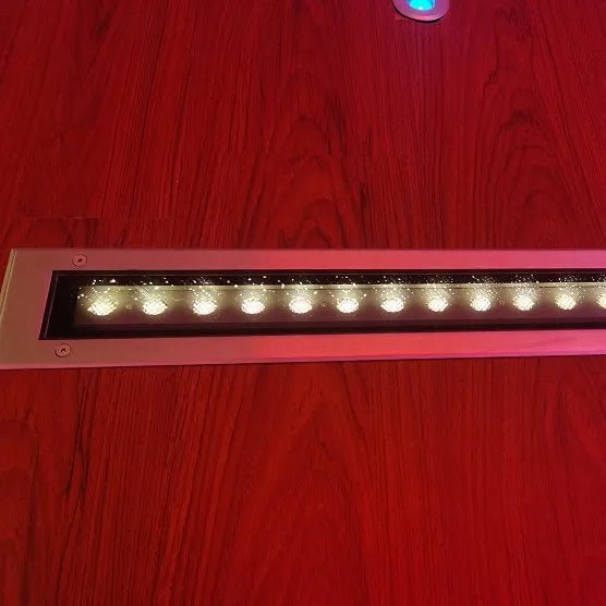 Linear LED light fixture on a red wooden surface