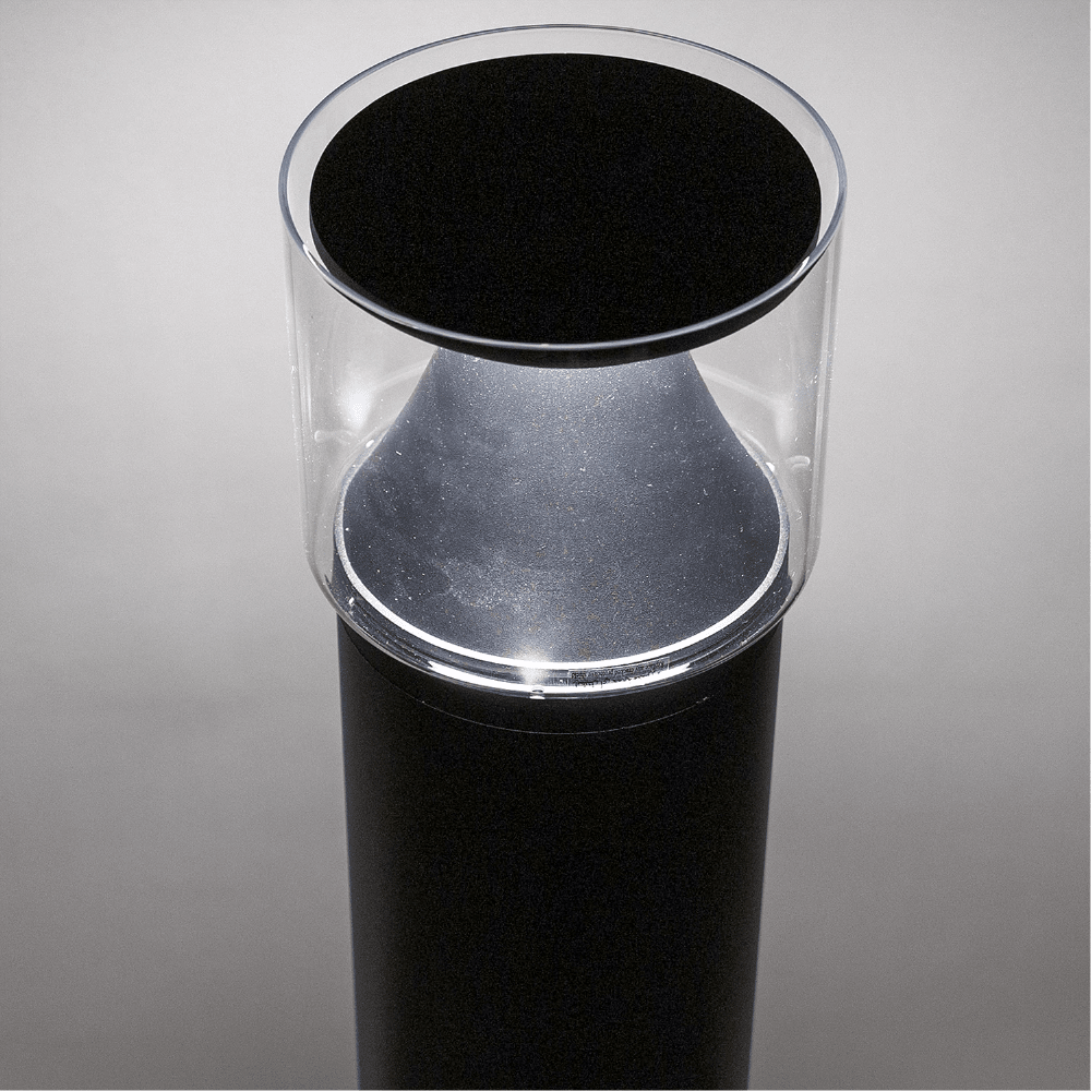 Black cylindrical object with a transparent top on a gray background