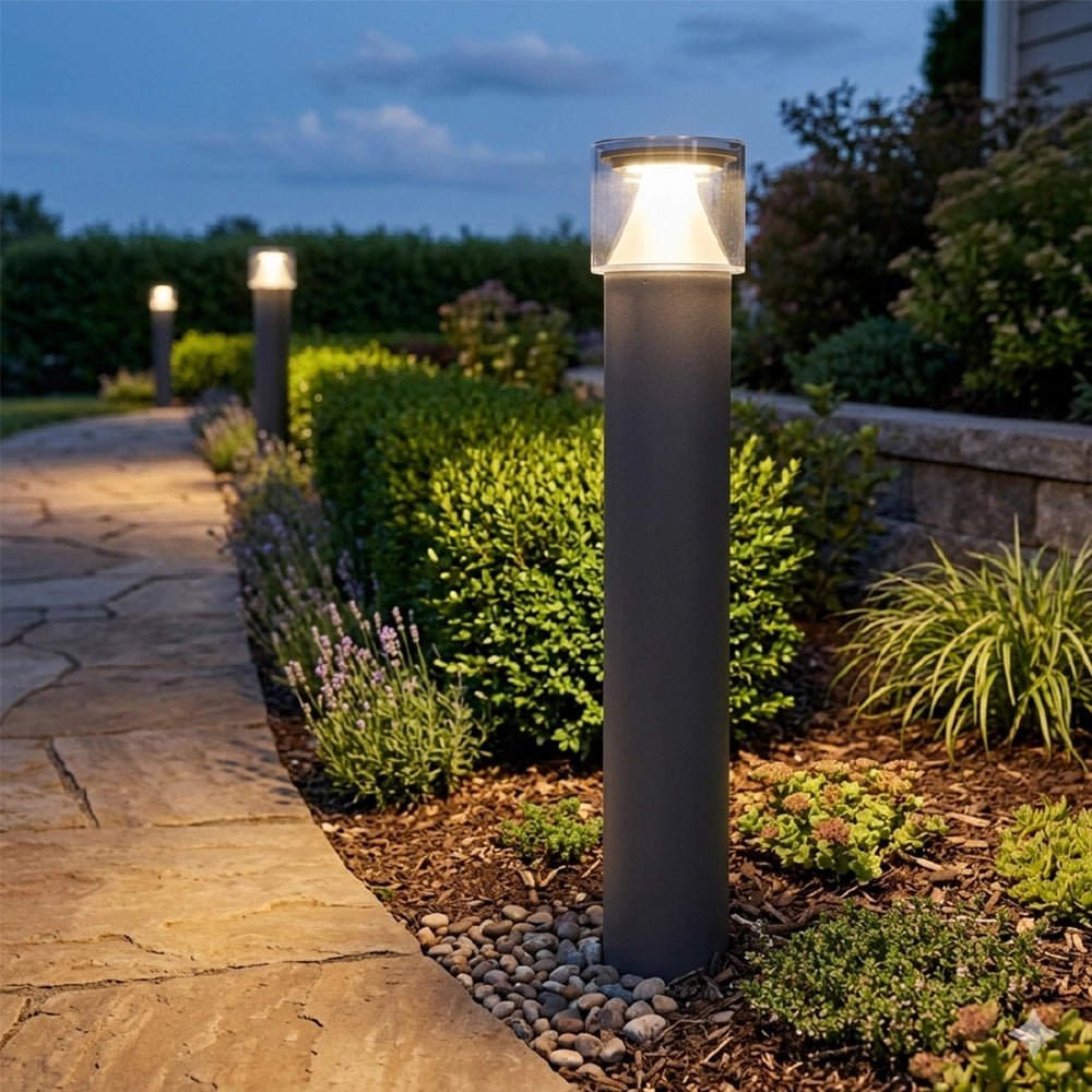Decorative outdoor lights illuminating a garden pathway at dusk.