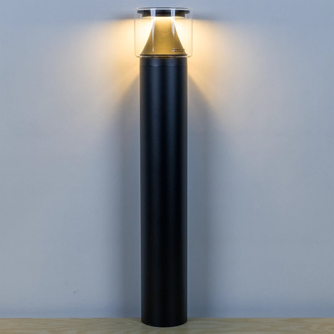 Black cylindrical outdoor light fixture on a gray background