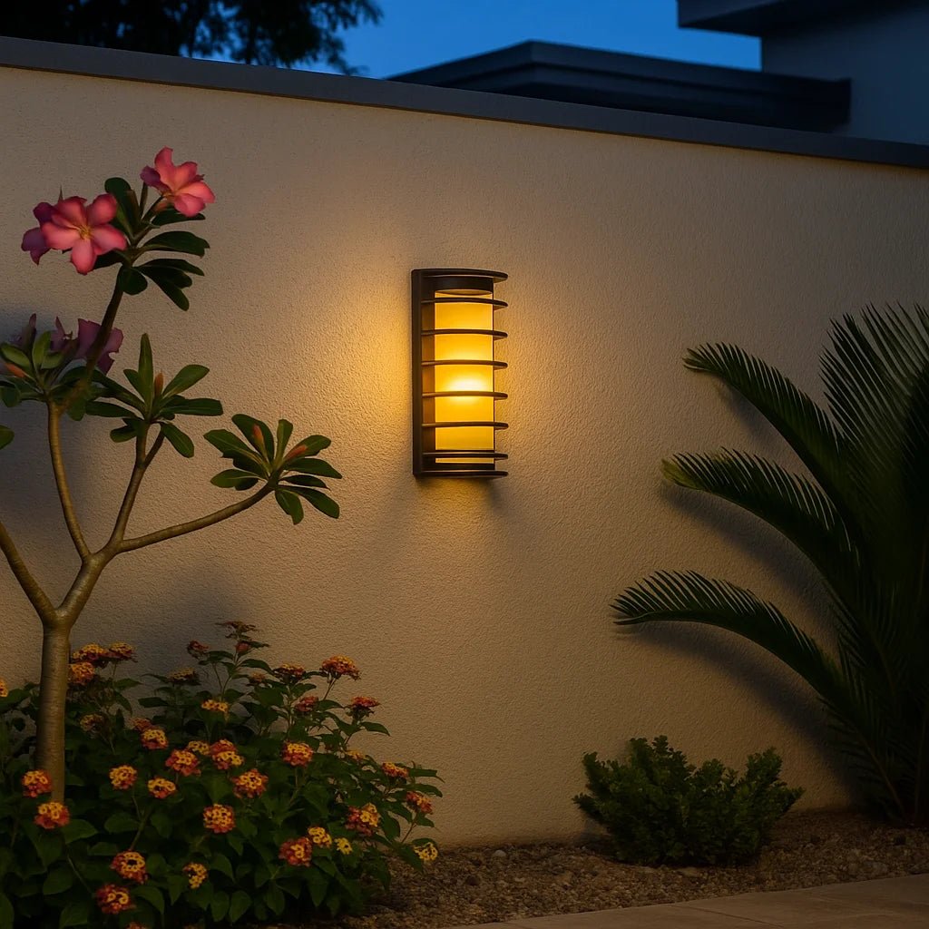 Outdoor wall light fixture on a garden wall with plants and flowers.