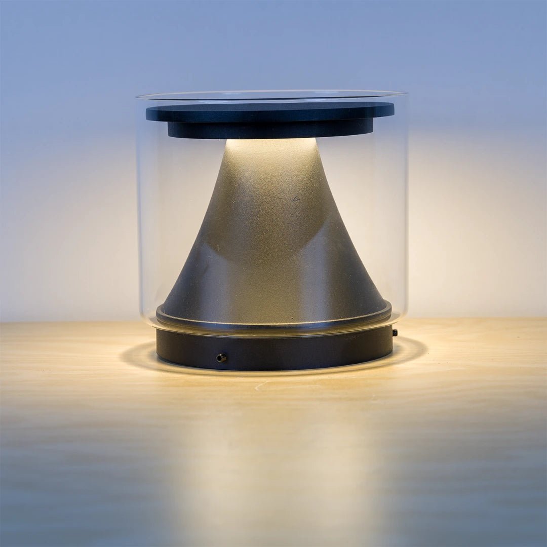 Cylindrical light fixture with clear cover on a wooden surface
