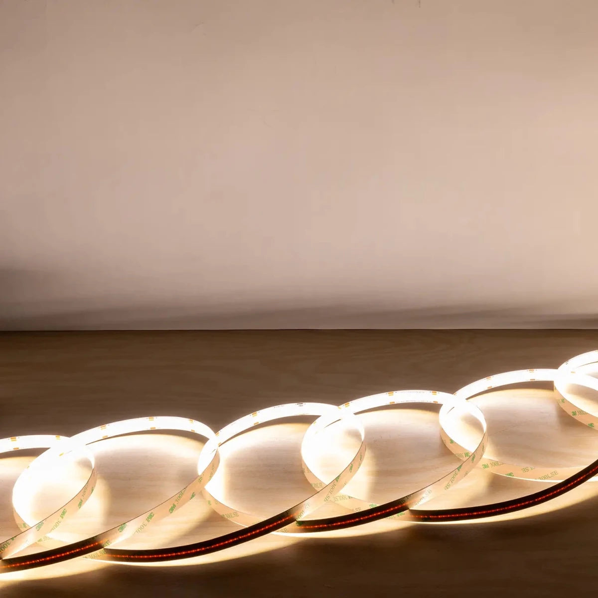 Close-up of LED strip lights on a wooden surface with a neutral background
