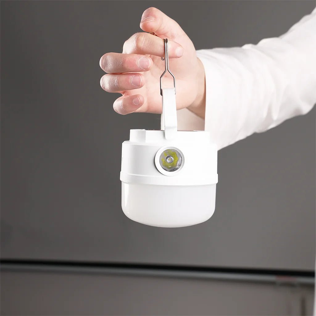 Hand holding a white electronic device with a dark background