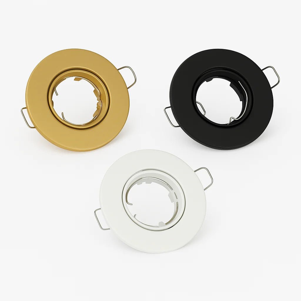 Three circular light fixture lenses in gold, black, and white on a white background