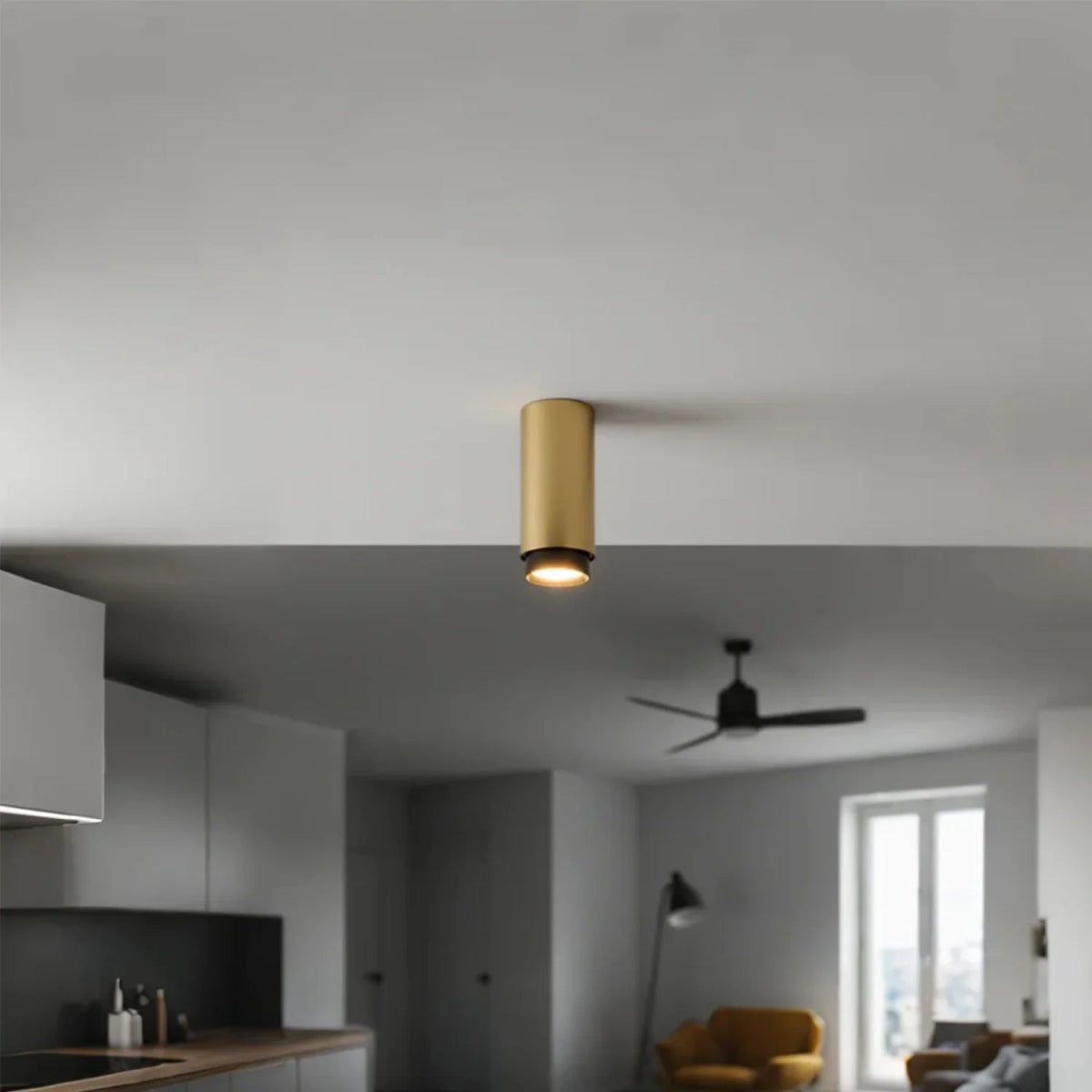 Modern ceiling light fixture in a living room with kitchen in the background