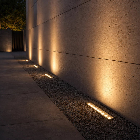 Modern outdoor lighting fixtures embedded in a concrete wall and pavement.