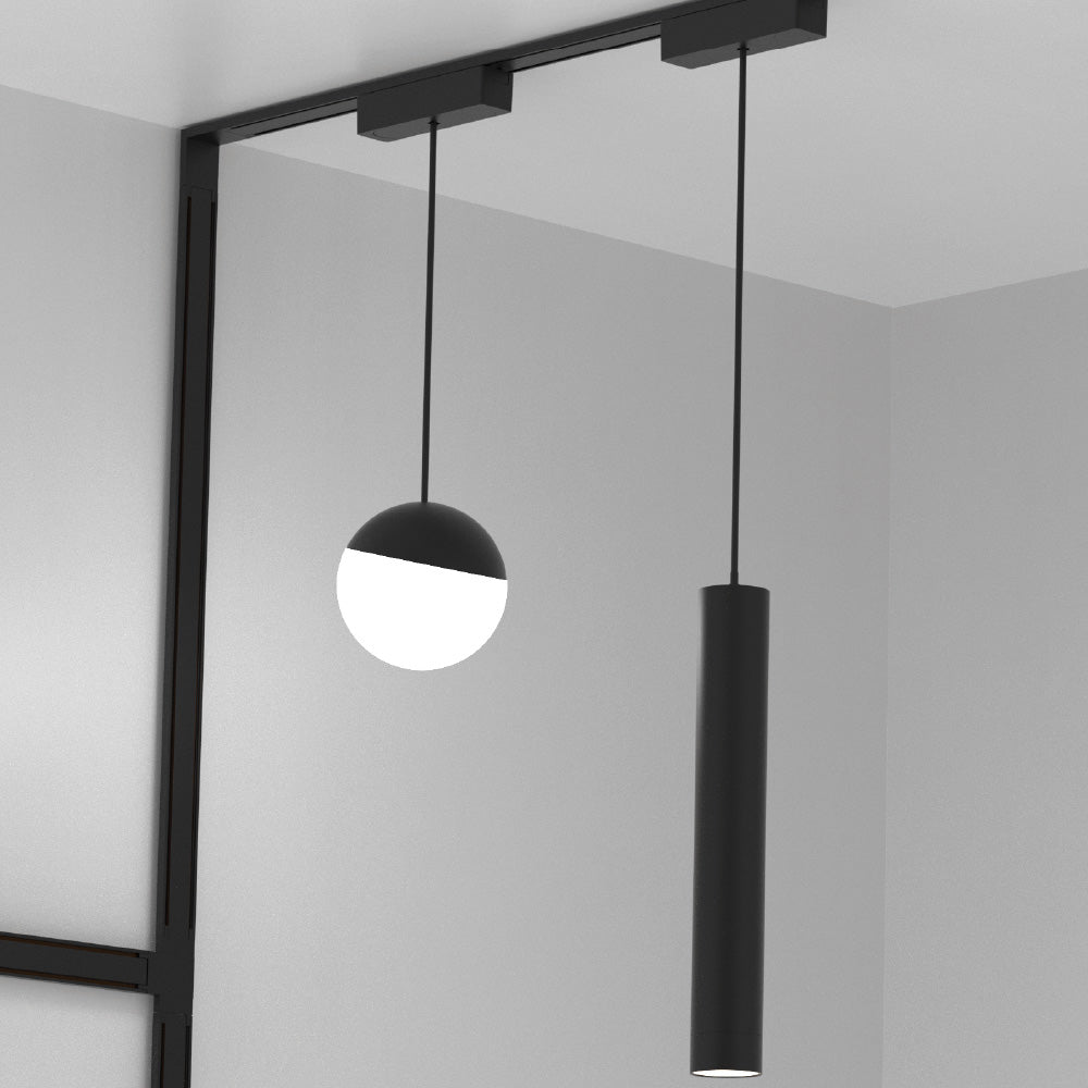 Modern pendant light fixture with black frame and cylindrical shade in a minimalistic setting.