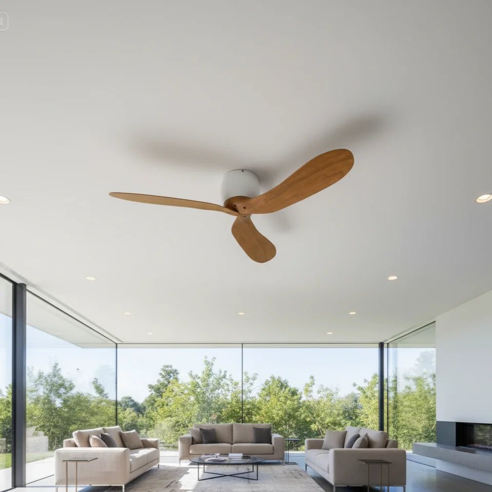 Modern ceiling fan in a living room with large windows and greenery outside