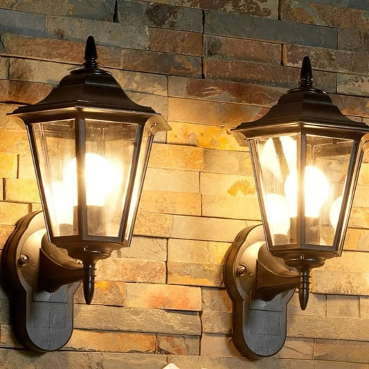 Two vintage-style wall lights on a stone wall.