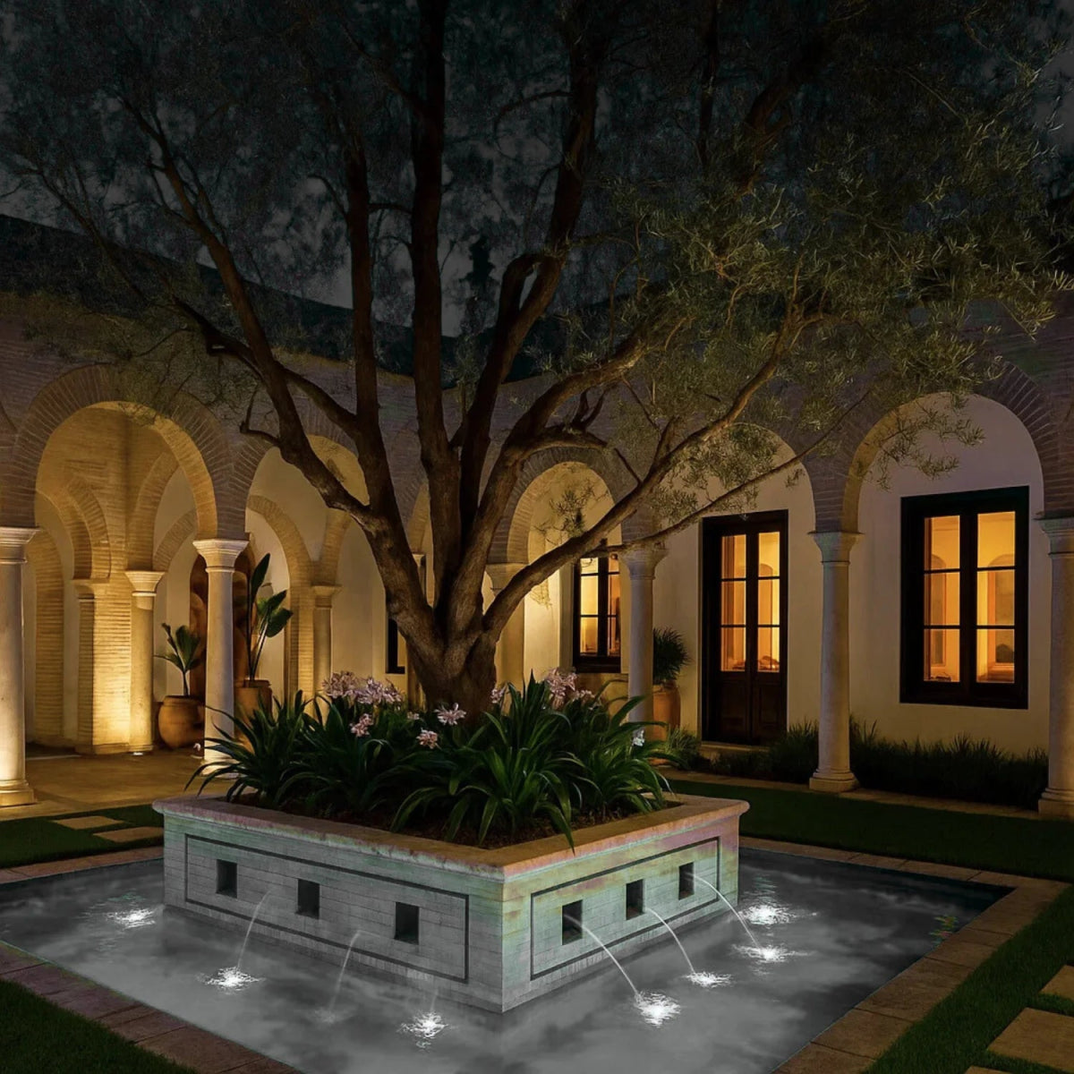 Decorative fountain in a courtyard with arches and trees at night.